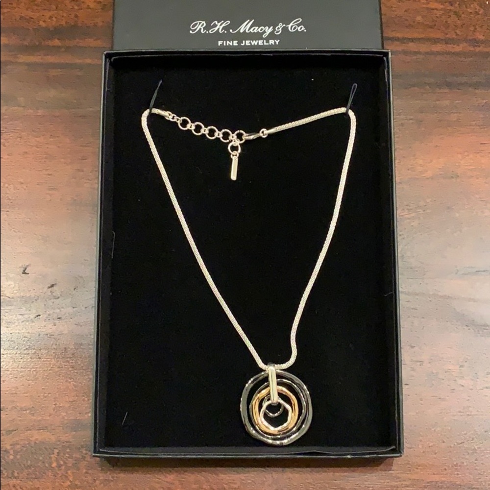 Silver-colored necklace. Pendant has 3 colors.